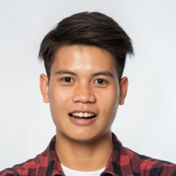 A young man in a red checkered shirt smiling with excitement, representing a happy user enjoying the KuyaPlay free bonus.